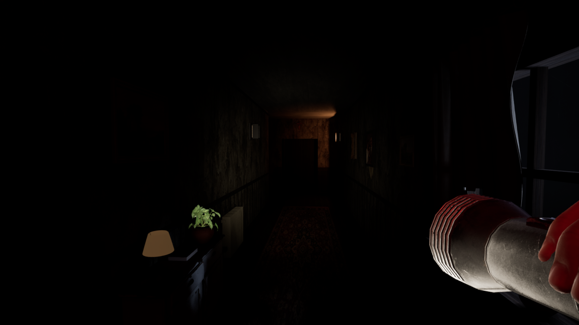 A flashlight held in the foreground of the same hallway after the lights go dark